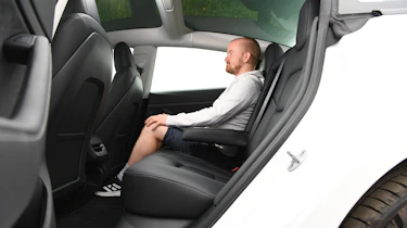 Auto Express chief reviewer Alex Ingram sitting in the Tesla Model 3's rear seats
