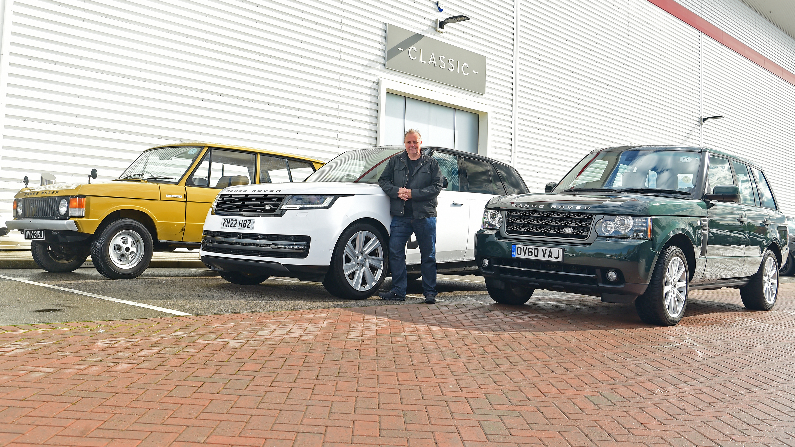 Auto Express editor-in-chief Steve Fowler standing with multiple generations of Range Rover
