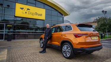 Auto Express staff photographer Pete Gibson standing with the Skoda Karoq outside of a Dogs Trust centre