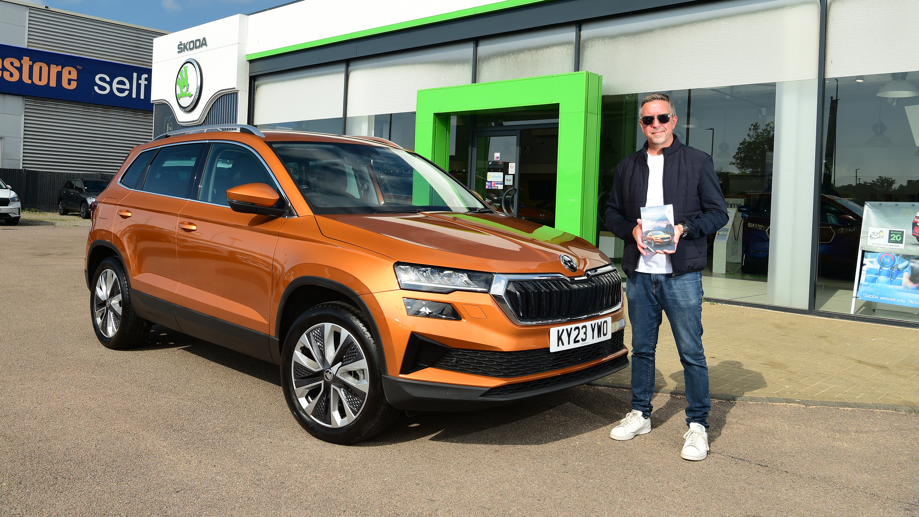 Auto Express staff photographer Pete Gibson next to the Skoda Karoq outside a Skoda dealership