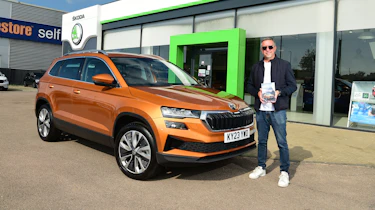 Auto Express staff photographer Pete Gibson next to the Skoda Karoq outside a Skoda dealership