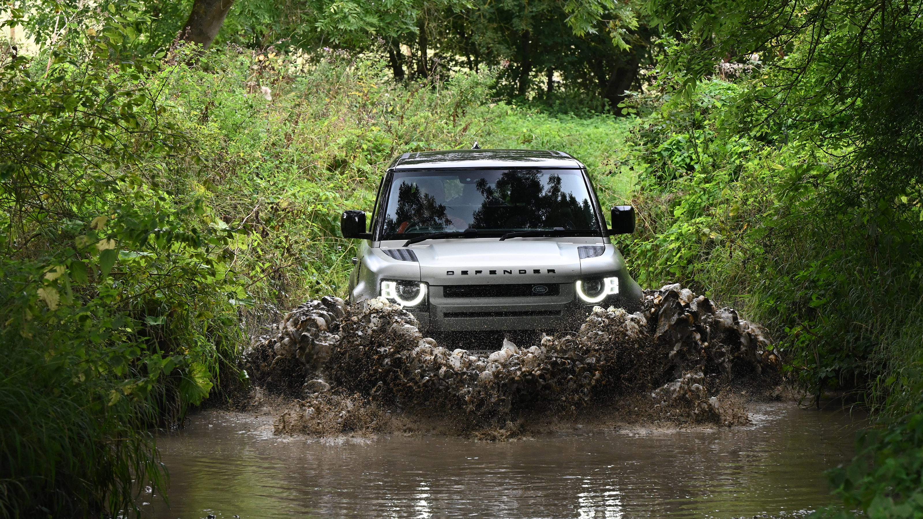 Land Rover Defender driving through a ford
