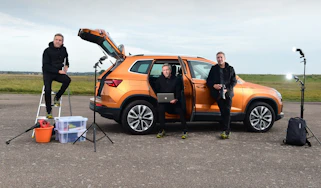 Auto Express staff photographer Pete Gibson standing in various poses next to the Skoda Karoq