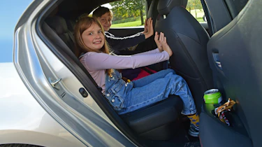 Auto Express features editor Chris Rosamond's children demonstrating the Toyota Corolla GR Sport's rear legroom
