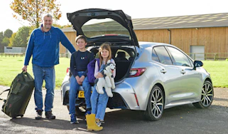 Auto Express features editor Chris Rosamond and his family standing behind the Toyota Corolla