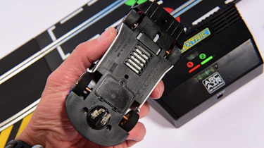 Auto Express product tester inspecting the underside of a slot car