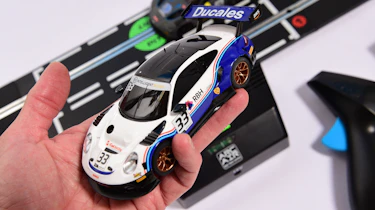 Auto Express product tester inspecting a Porsche slot car