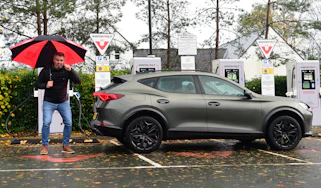 Auto Express deputy editor Richard Ingram standing with the Cupra Formentor in front of an array of Instavolt chargers