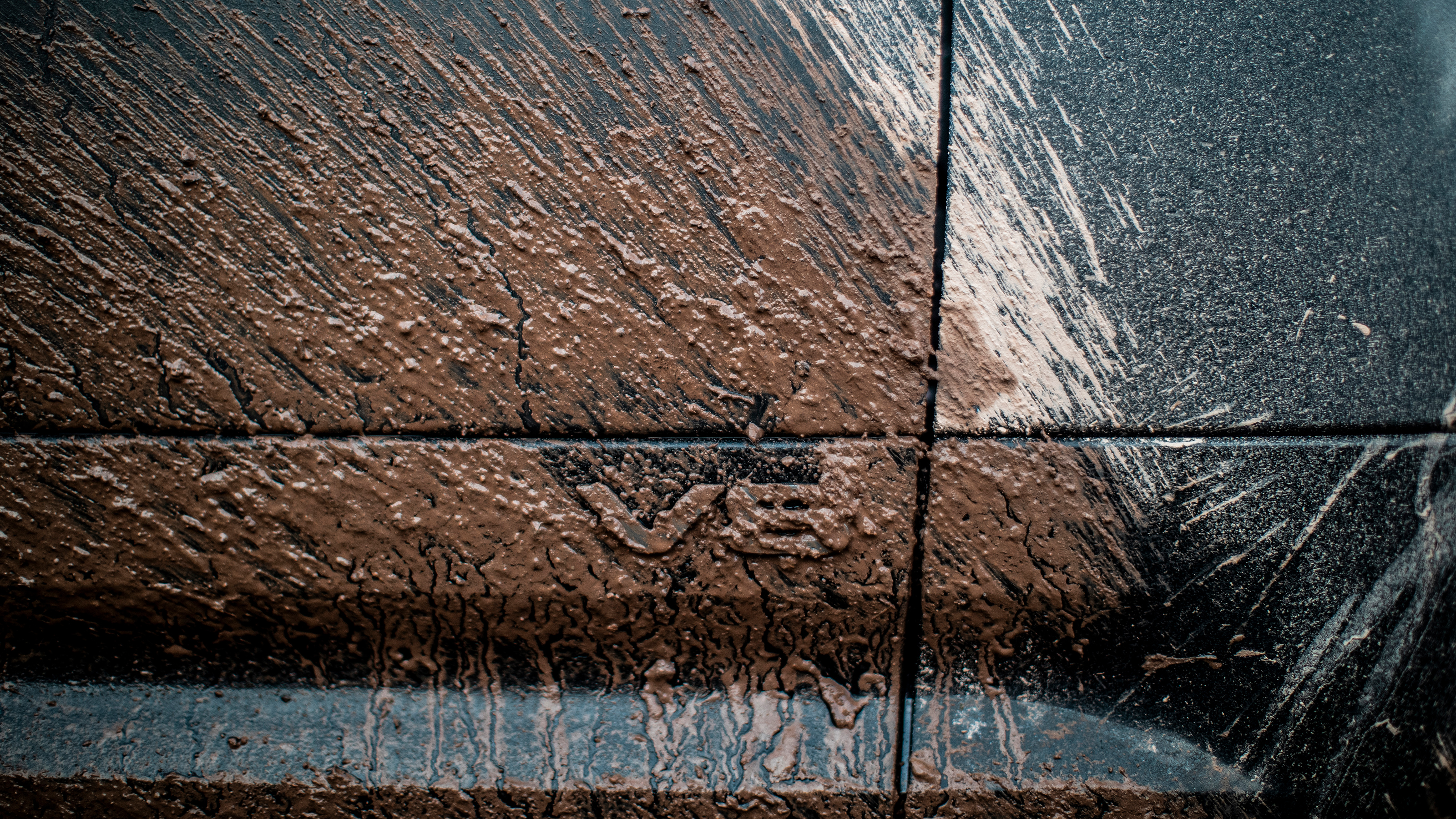 Land Rover Defender 130 P500 AWD - muddied V8 badge