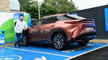 Auto Express creative director Darren Wilson standing with the Lexus RZ in a charging bay