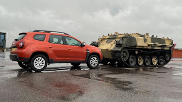Dacia Duster parked opposite a tank