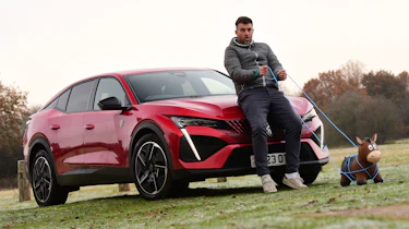 Auto Express head of digital content Steve Walker leaning on the Peugeot 408 GT while holding a toy horse