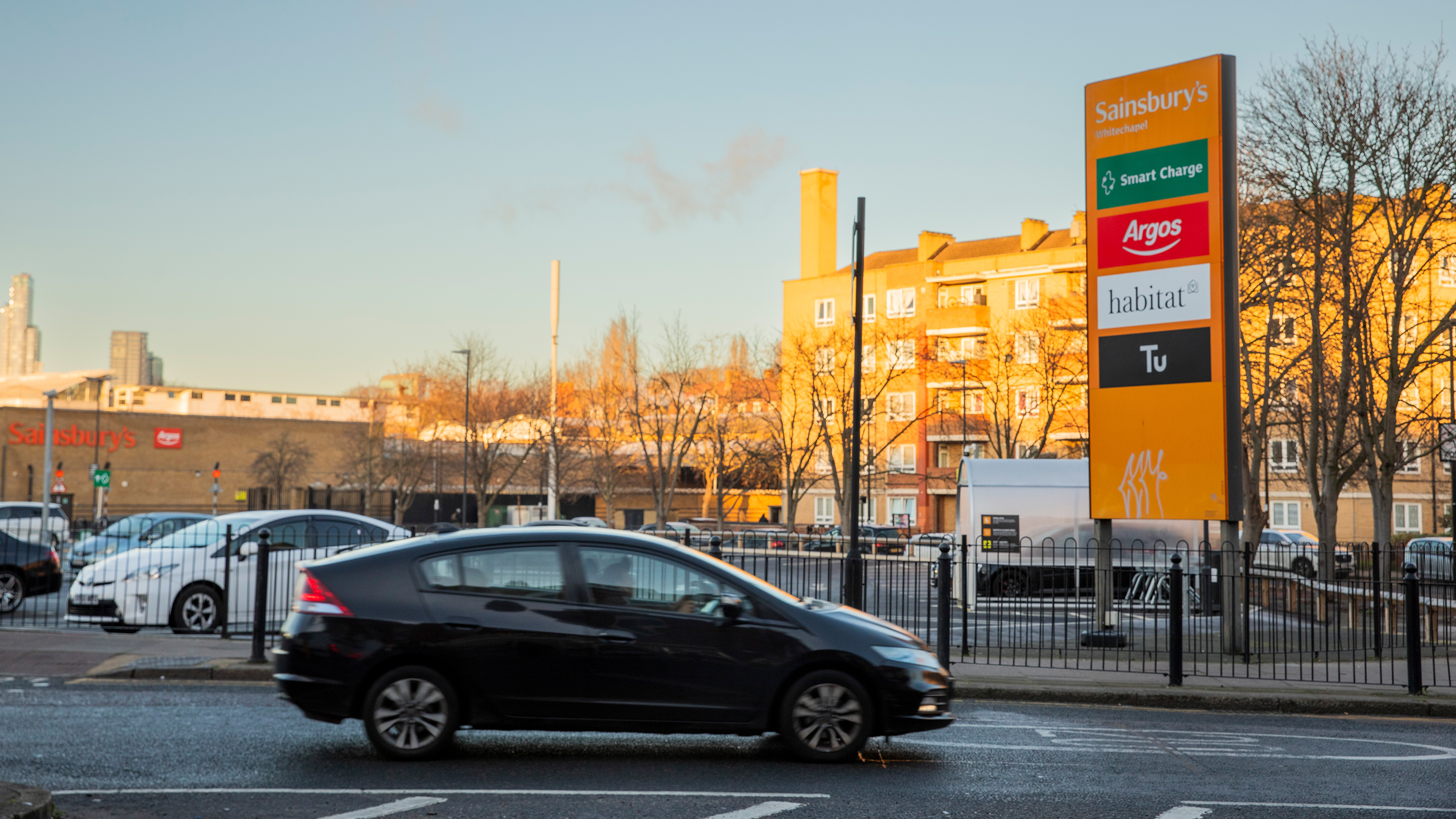 Honda Insight driving past Sainsburys supermarket