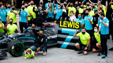 Lewis Hamilton sitting with pit crew