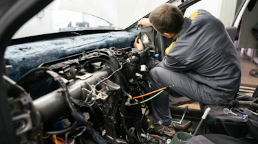 Technician working on dashboard wiring