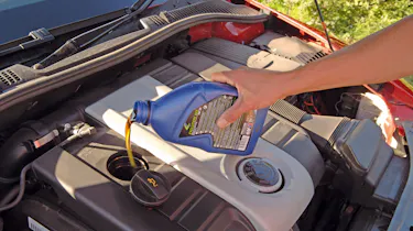 Person topping up engine oil