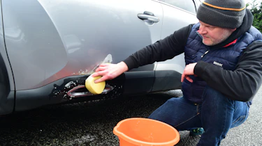 Auto Express executive editor Paul Adam washing the Citroen C4 X's wheel