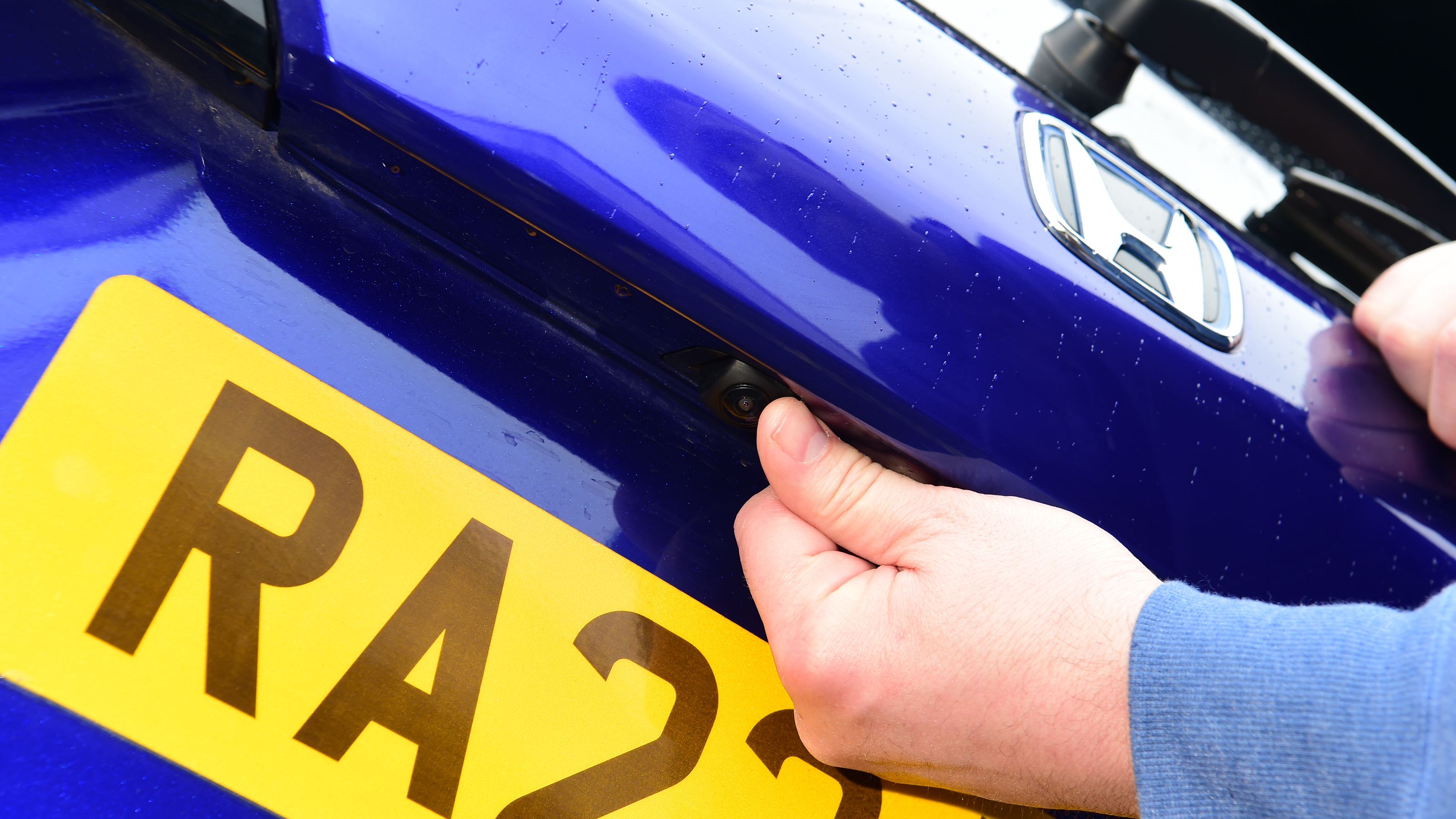 Auto Express current affairs and features editor Chris Rosamond pointing at the Honda ZR-V's tailgate-mounted sensor