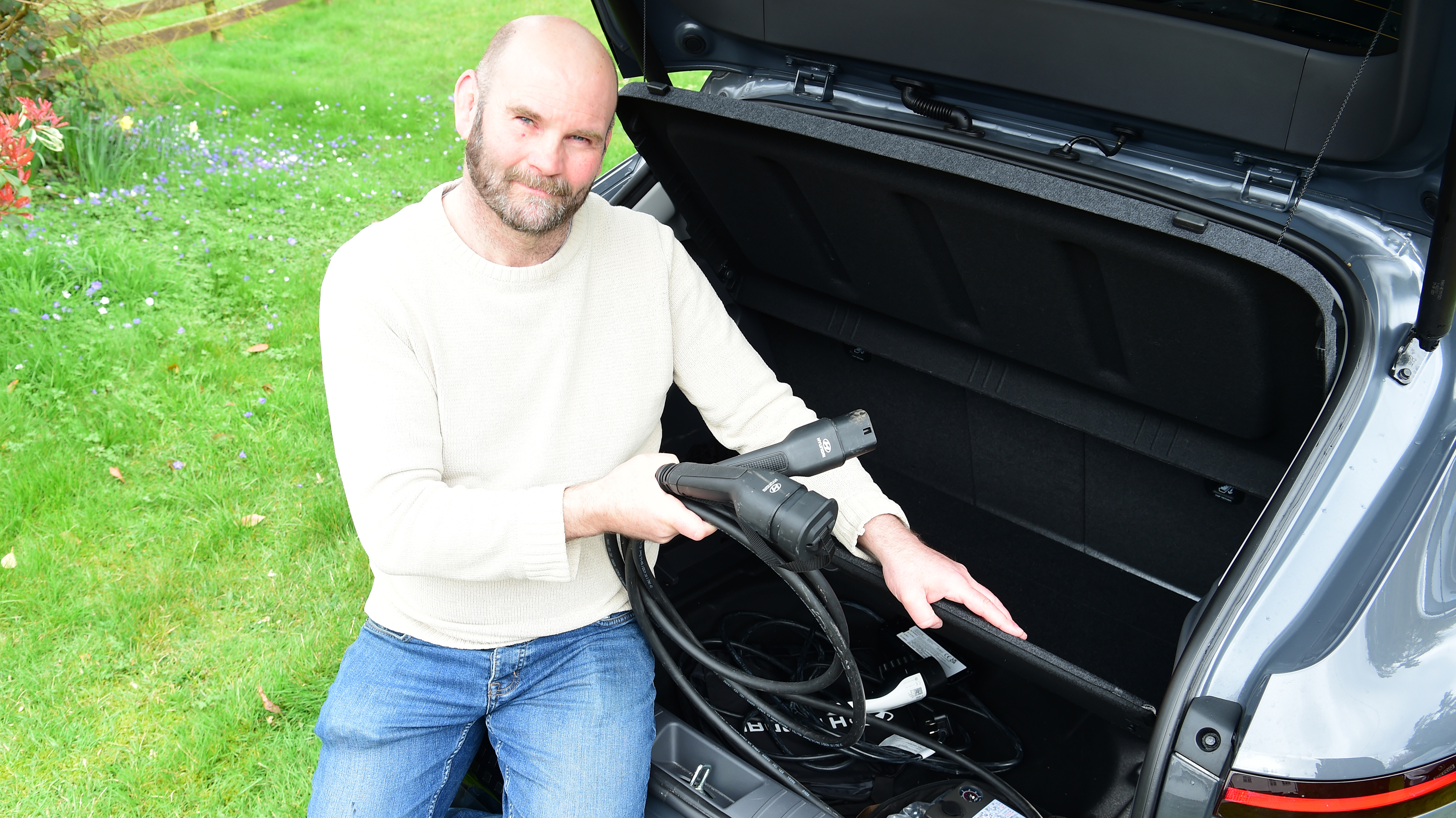 Auto Express creative director Darren Wilson removing charging cables from the Hyundai Kona Electric's boot