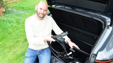 Auto Express creative director Darren Wilson removing charging cables from the Hyundai Kona Electric's boot