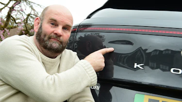 Auto Express creative director Darren Wilson pointing at the Hyundai Kona Electric's dented tailgate