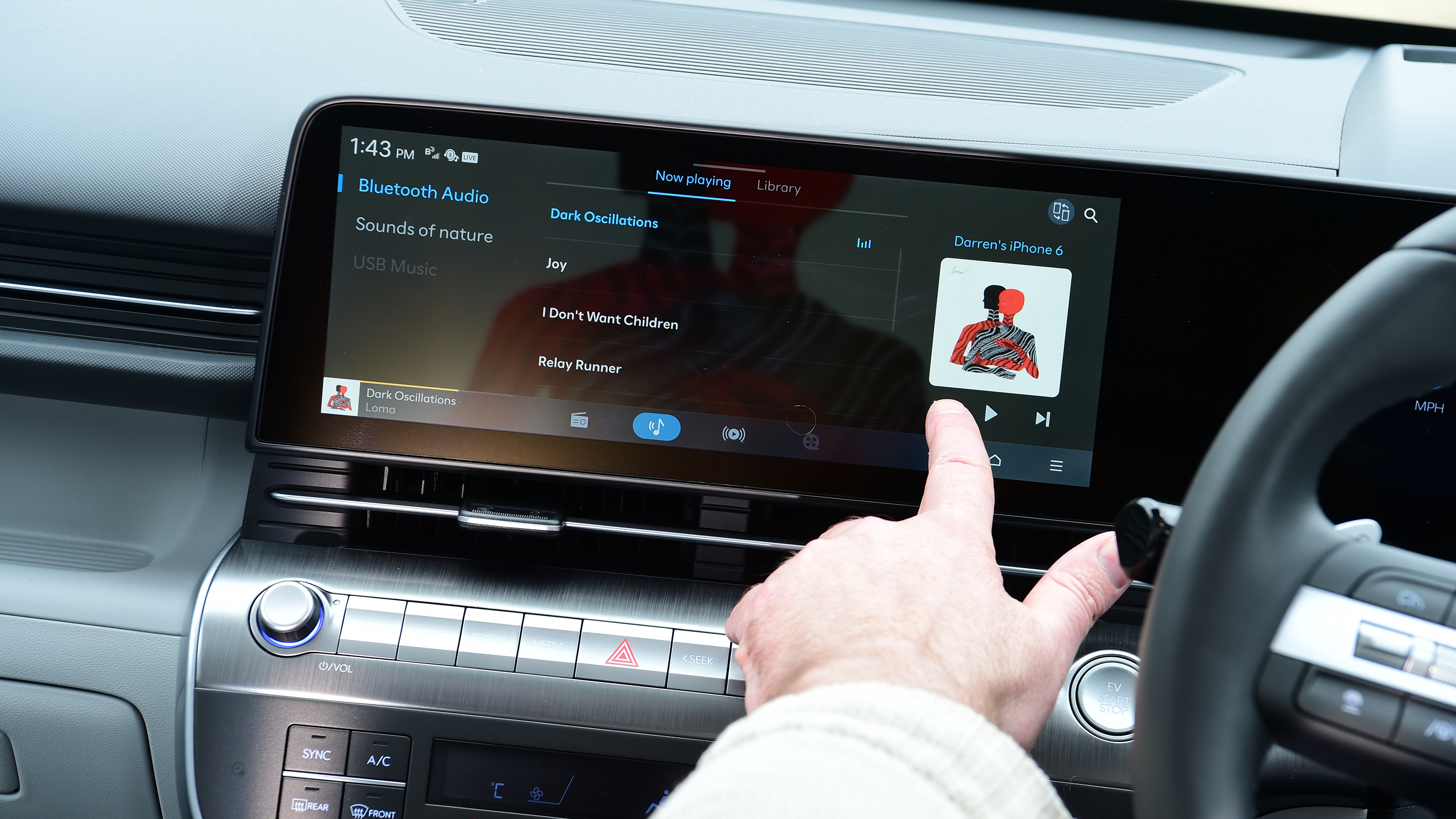 Auto Express creative director Darren Wilson operating the Hyundai Kona Electric's infotainment system