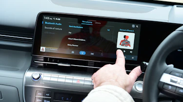 Auto Express creative director Darren Wilson operating the Hyundai Kona Electric's infotainment system