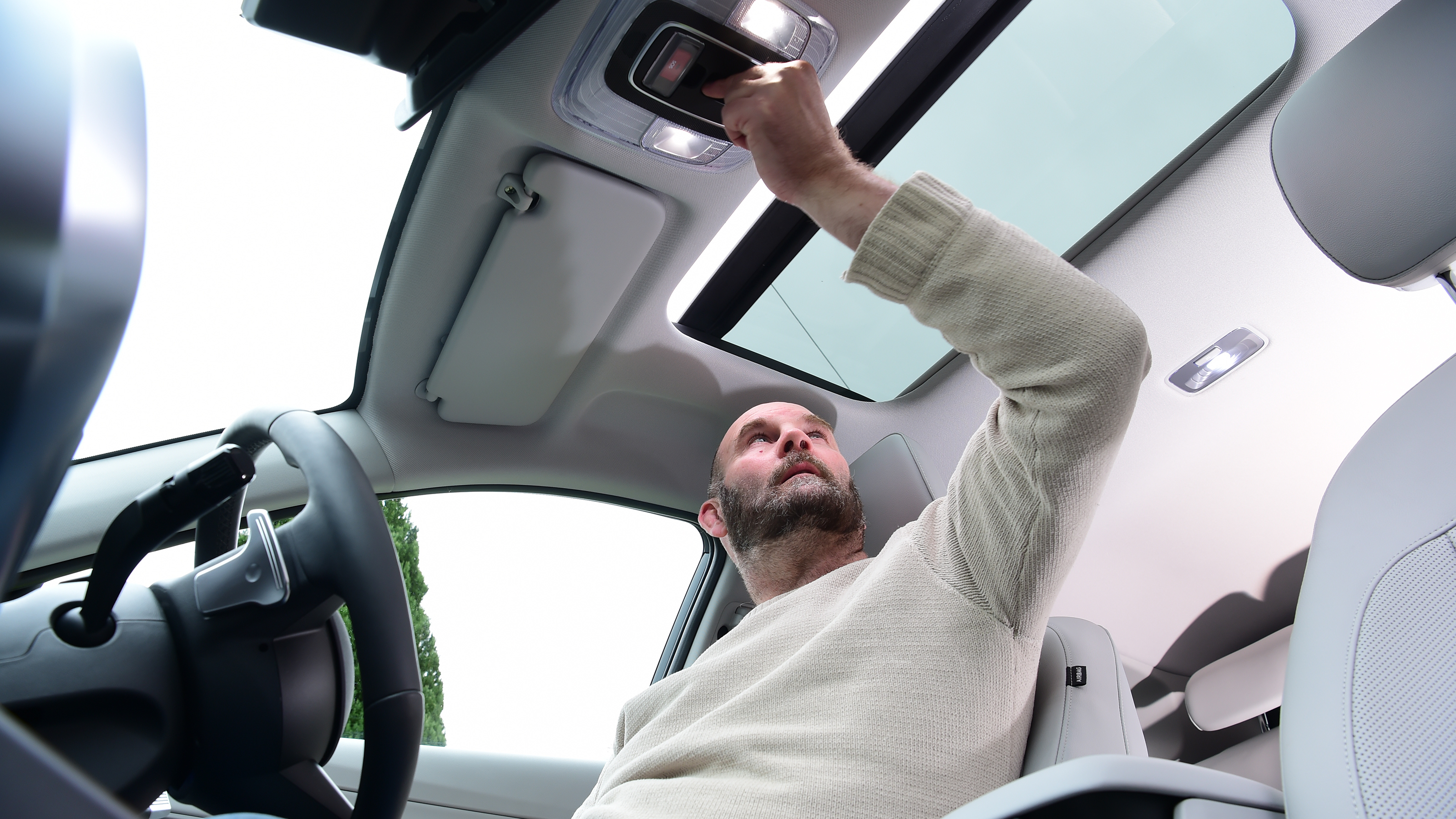Auto Express creative director Darren Wilson operating the Hyundai Kona Electric's sunroof