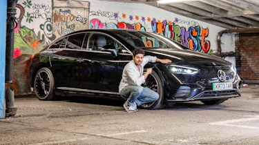 Auto Express senior staff writer Jordan Katsianis crouching next to the Mercedes EQE