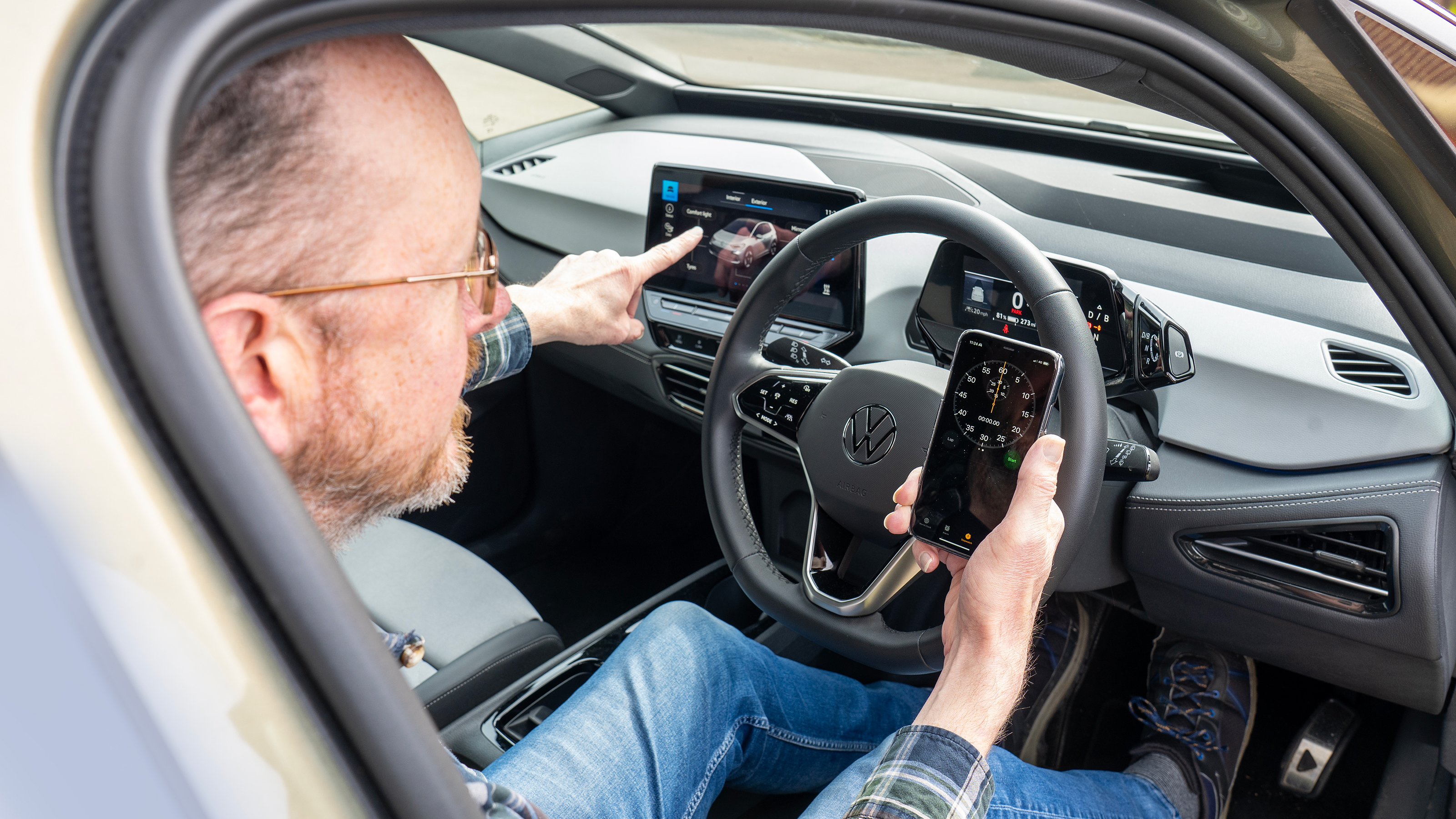 Auto Express chief sub editor Andy Pringle using a phone stopwatch app while sitting in the Volkswagen ID.3