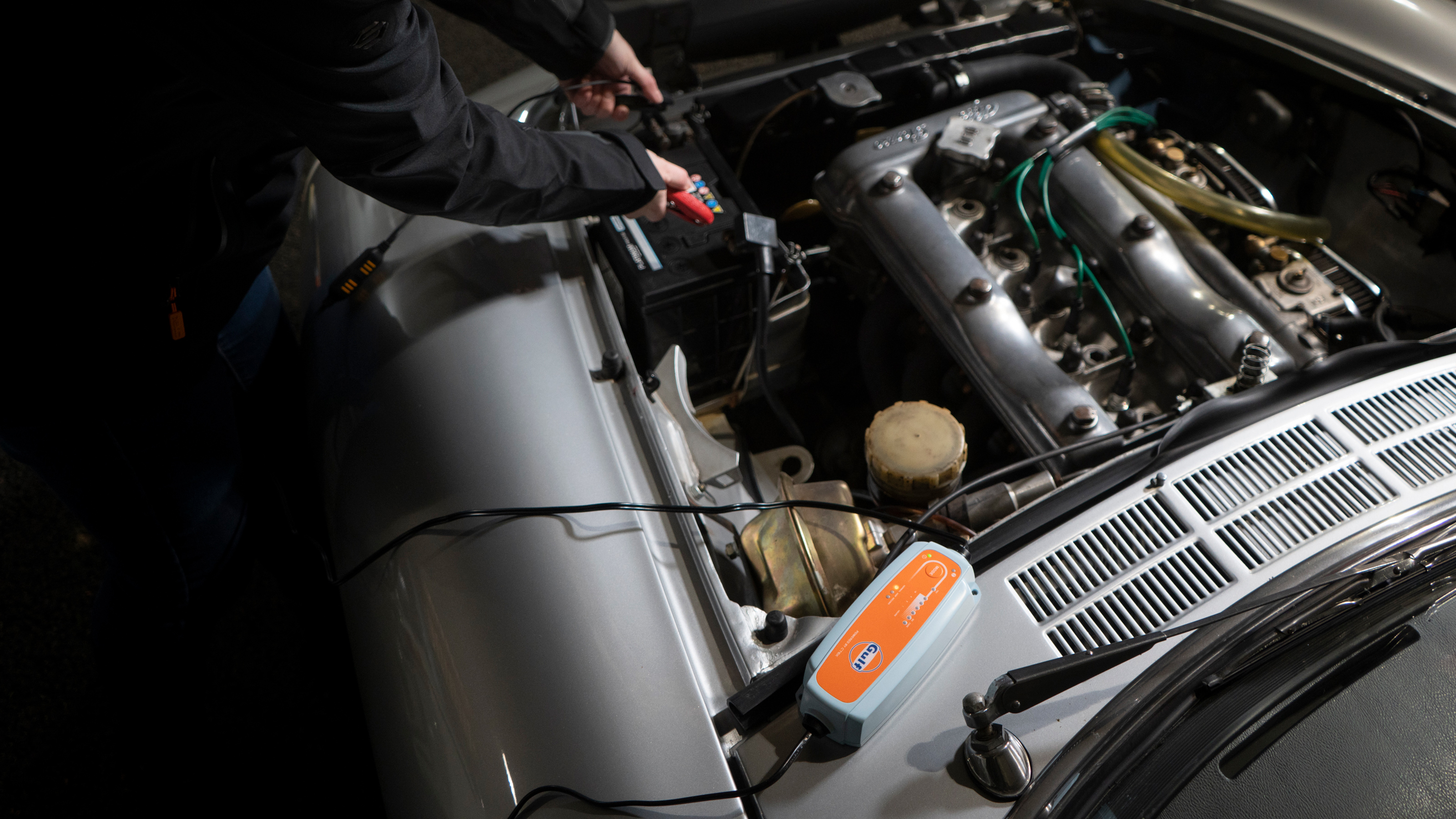 Battery charger connected to a classic car's battery