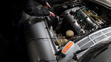 Battery charger connected to a classic car's battery
