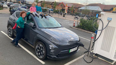 Auto Express creative director Darren Wilson's family standing with the Hyundai Kona while charging
