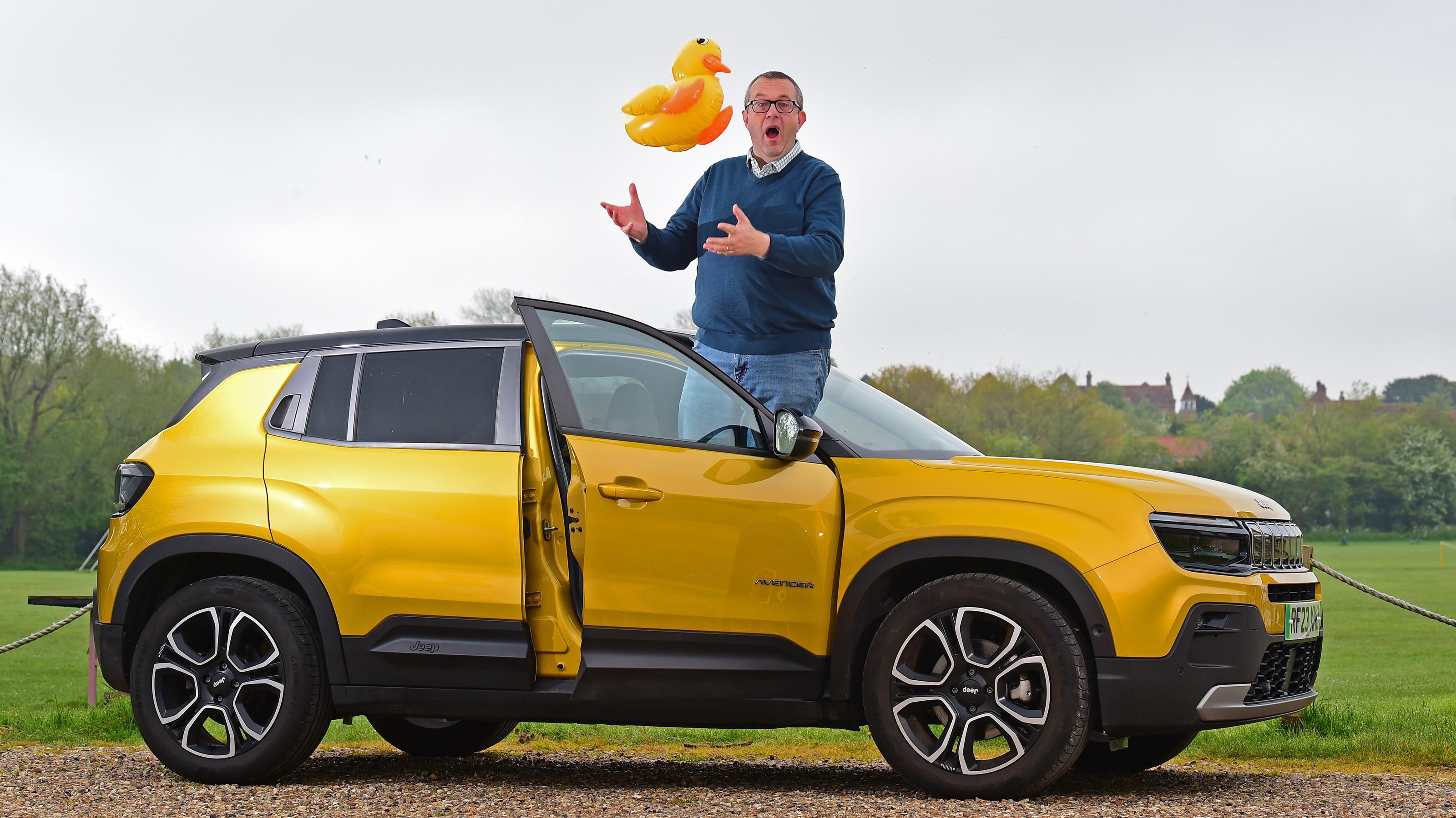 Auto Express editor-at-large John McIlroy standing on the Jeep Avenger's door sill while holding an inflatable duck 