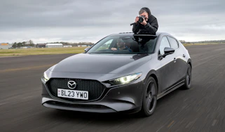 Auto Express senior photographer Pete Gibson taking photos through the Mazda 3's open sunroof