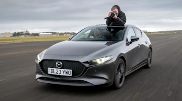 Auto Express senior photographer Pete Gibson taking photos through the Mazda 3's open sunroof