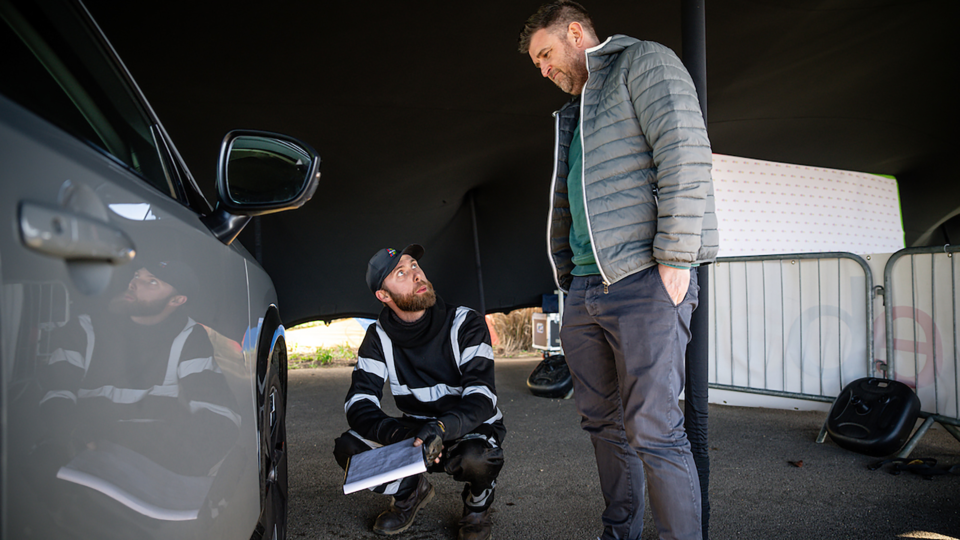 Auto Express head of digital content Steve Walker talking to a technician inspecting the Nissan Ariya