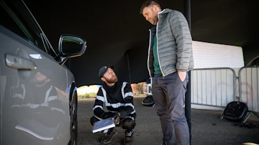 Auto Express head of digital content Steve Walker talking to a technician inspecting the Nissan Ariya