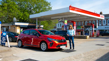 Auto Express pictures editor Dawn Grant standing next to the Renault Clio at an Esso forecourt