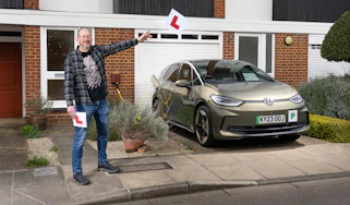 Auto Express chief sub-editor Andy Pringle holding two L-plates while standing next to the Volkswagen ID.3