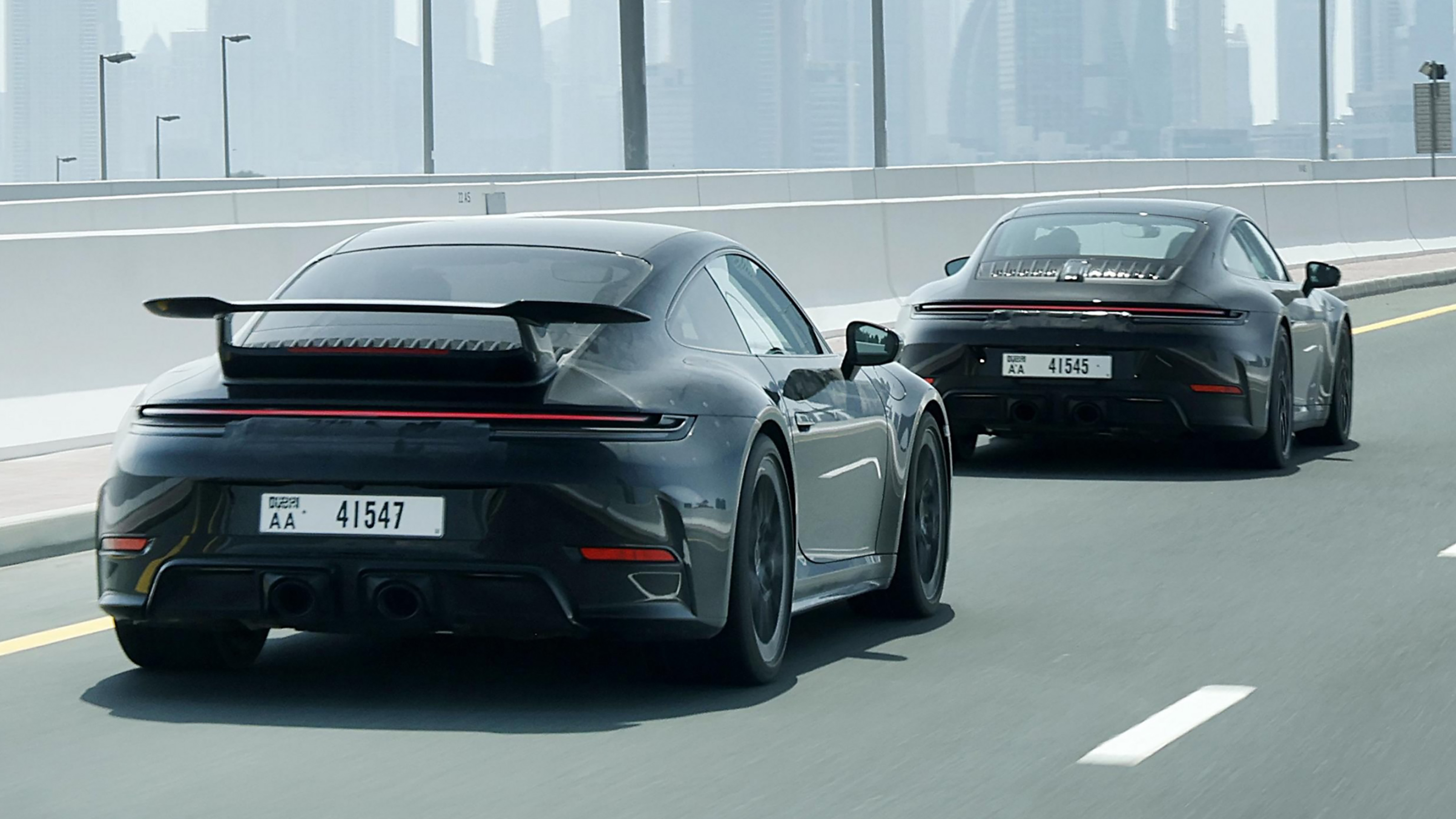 New Porsche 911's rear 3/4 driving down a road