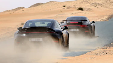New Porsche 911's rear 3/4 driving down a desert road