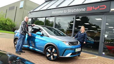 Auto Express chief sub-editor Andy Pringle and BYD representative Sophie Barella standing outside a BYD showroom