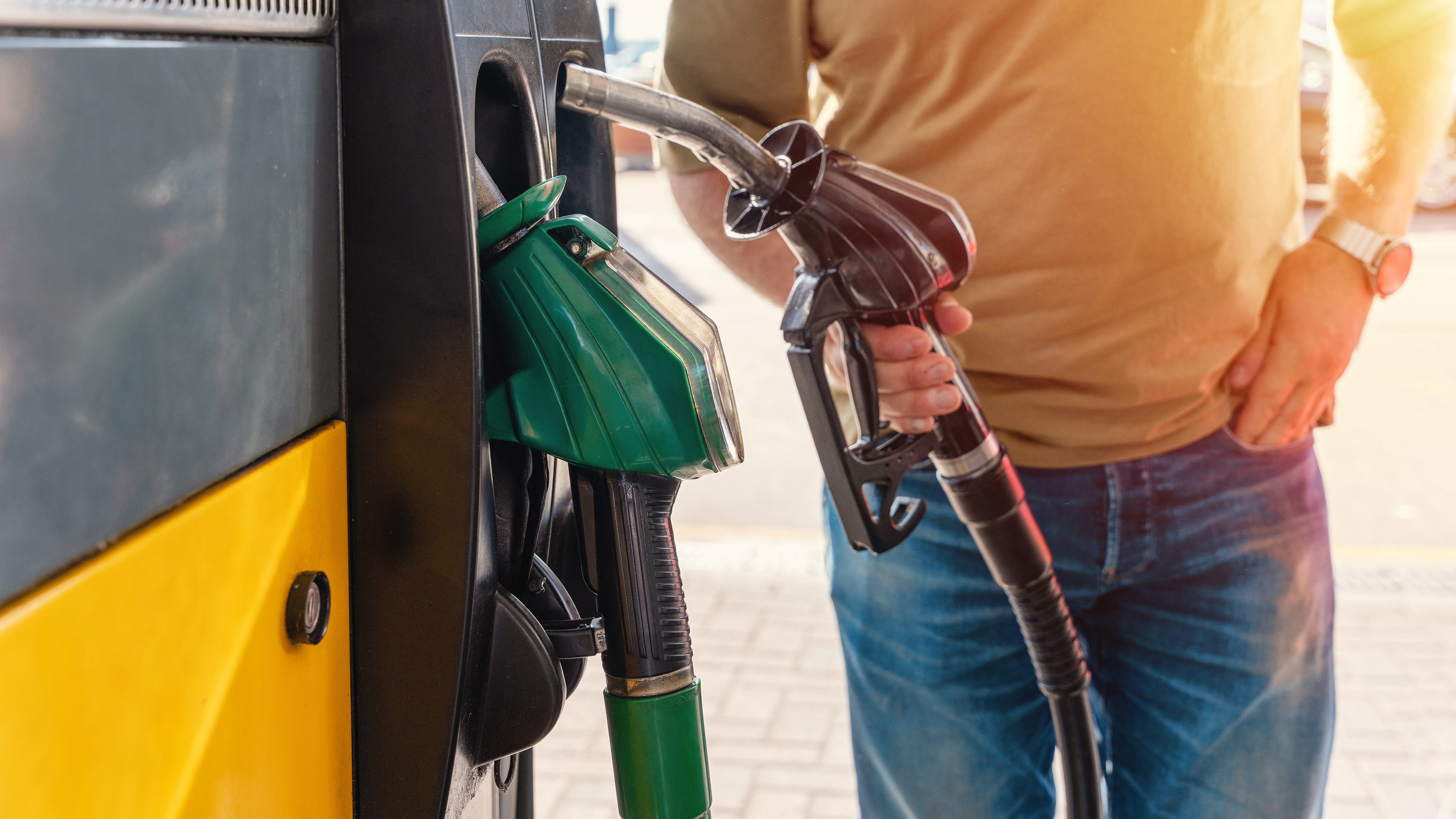 Person picking up a fuel pump nozzle