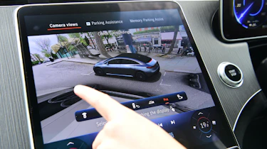 Auto Express senior staff writer Jordan Katsianis operating the Mercedes EQE's touchscreen