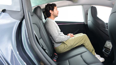 Auto Express senior staff writer Jordan Katsianis sitting in the Tesla Model 3 Performance's back seat