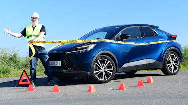 Auto Express commercial editor Paul Adam standing next to the Toyota C-HR while wearing a hard hat and high-vis jacket