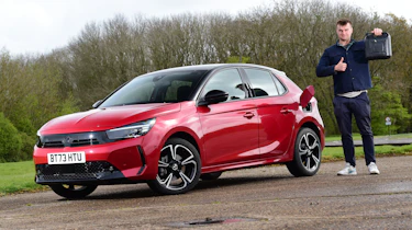 Auto Express senior news reporter Alastair Crooks standing next to the Vauxhall Corsa GS and holding a jerry can
