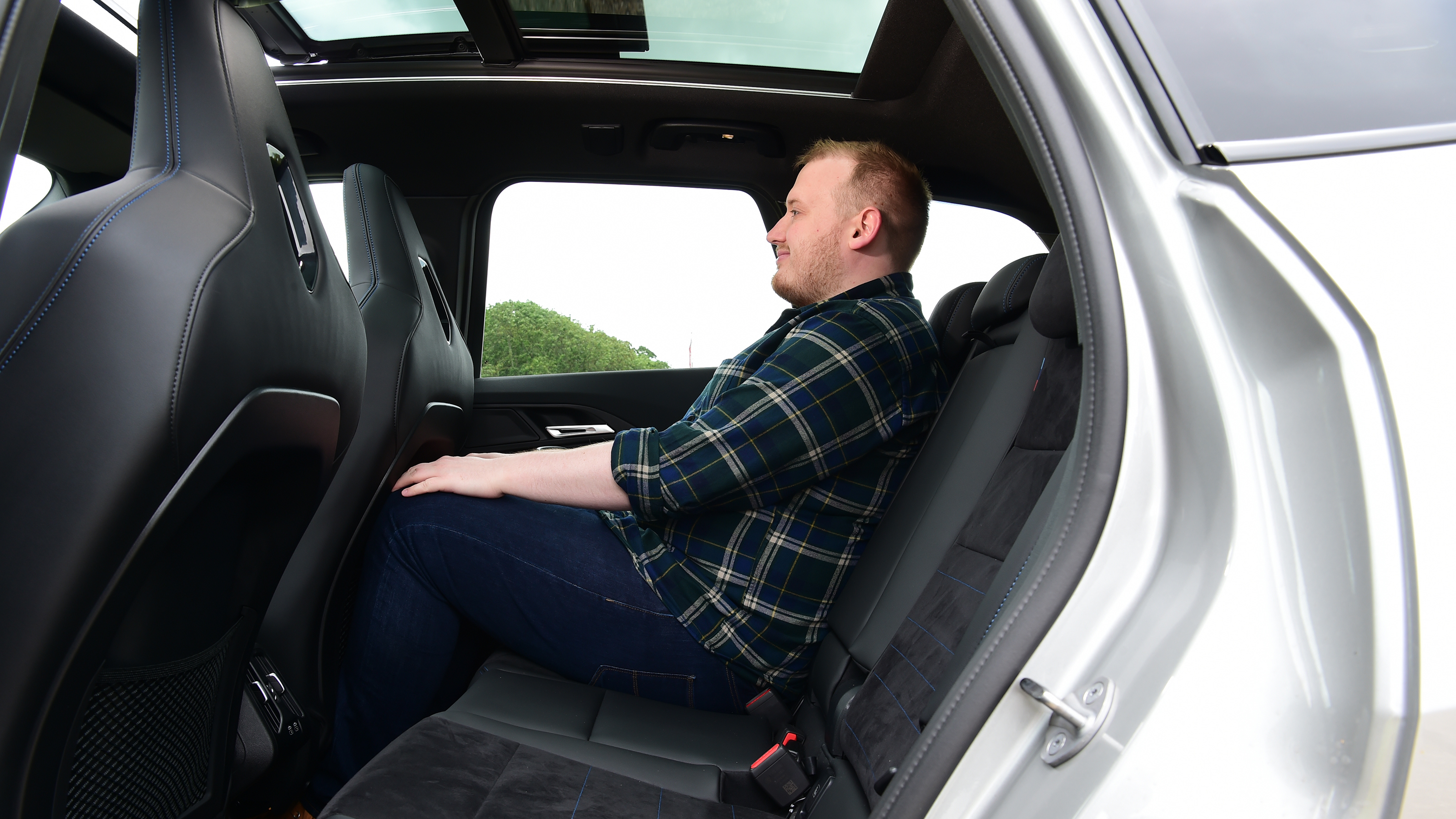 Auto Express news reporter Ellis Hyde sitting in the BMW iX1's back seat