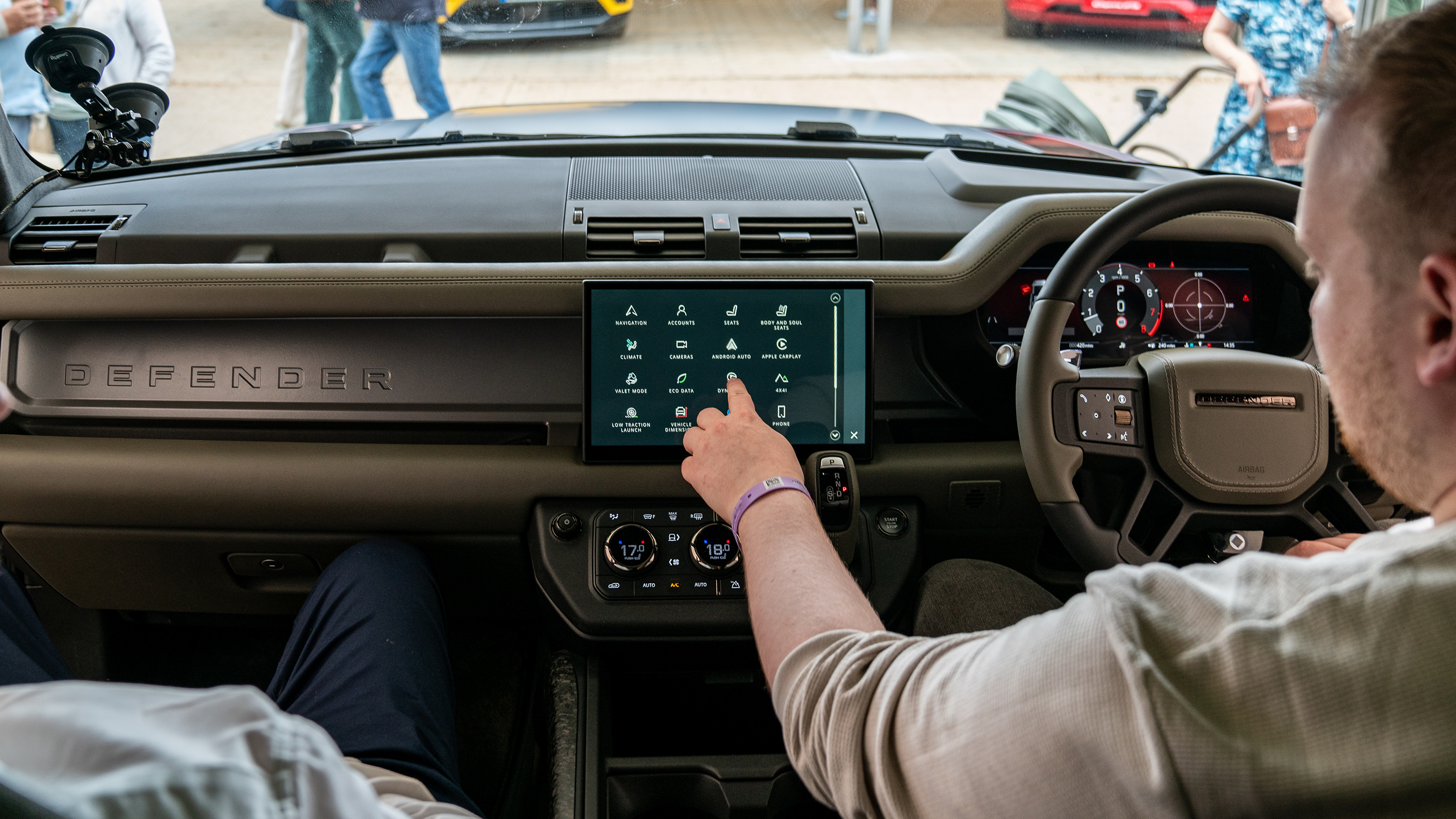 Auto Express news reporter Ellis Hyde operating the Land Rover Defender OCTA's infotainment sytem